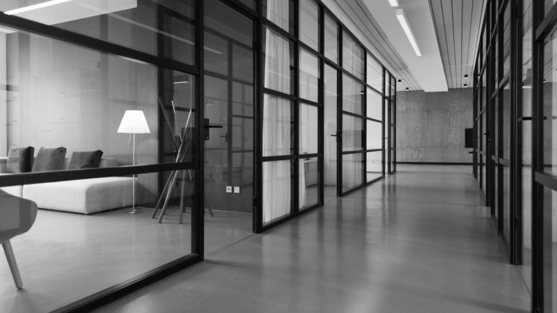 surface mounted linear led luminaires in a hallway with glass office walls