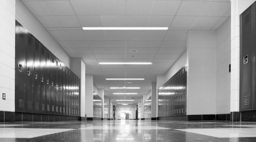 recessed linear LED light fixtures in a school hallway with lockers